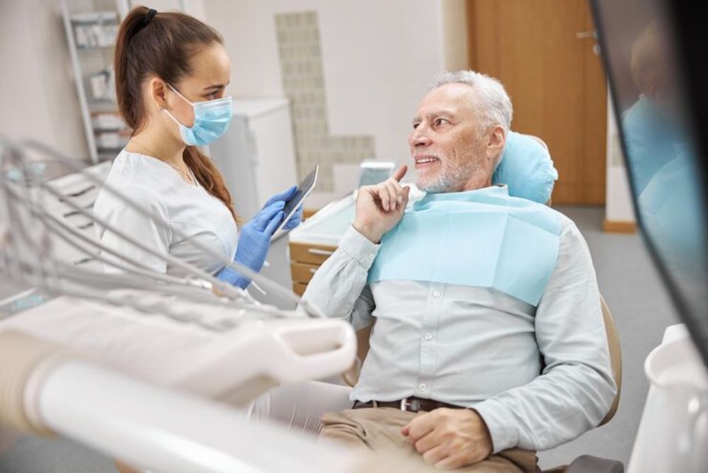 senior patient discussing dental implant treatment options with a dentist during a consultation